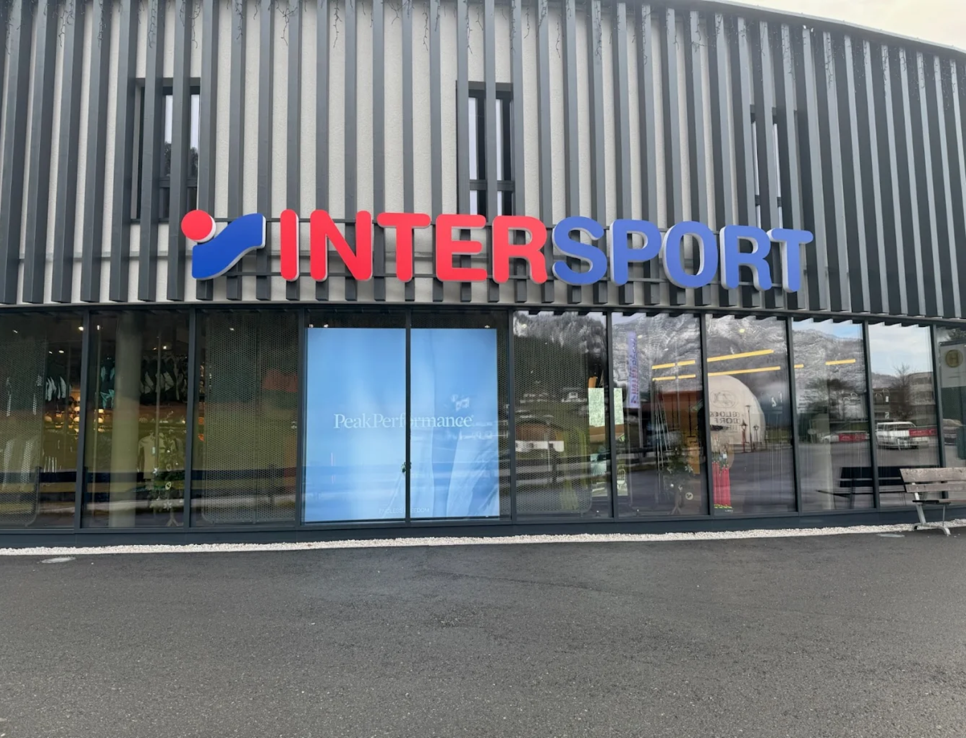 Außenansicht eines Intersport-Geschäfts mit moderner Fassade, großen Glasfenstern und gut sichtbarem Logo. Die Atmosphäre ist ruhig und einladend.