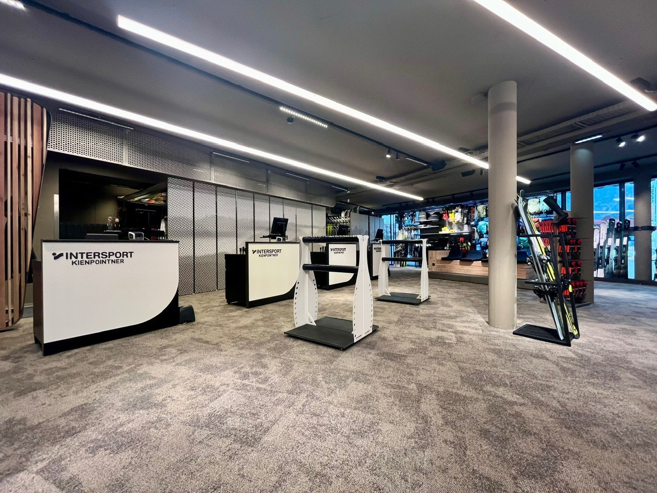 Intersport store interior with checkout counters, ski equipment, and modern design.