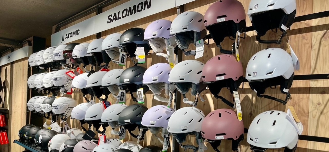 Ausstellung von Salomon- und Atomic-Ski- und Snowboardhelmen in verschiedenen Farben für die Sicherheit beim Wintersport.