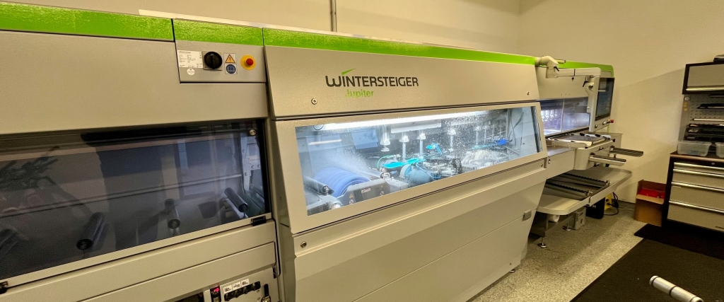 Wintersteiger Jupiter ski tuning machine, close-up view of the automated ski service equipment.