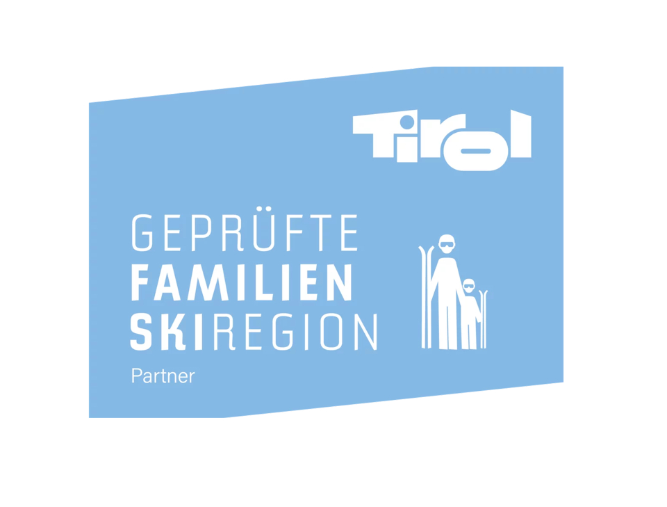 Blaues Logo mit weißem Schriftzug „Tirol“ und „Geprüfte Familienskiregion Partner“, dargestellt mit einem einfachen Bild von zwei Skifahrern, einem Erwachsenen und einem Kind, das familienfreundliches Skifahren vermittelt.